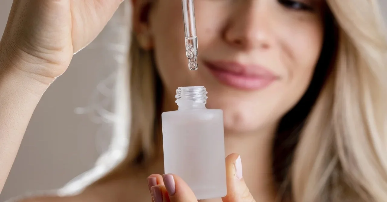 Kobieta trzymająca otwartą buteleczkę z serum